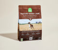 Open Farm pasture-raised lamb & ancient grains dry dog food bag with a boxer dog in a golden field